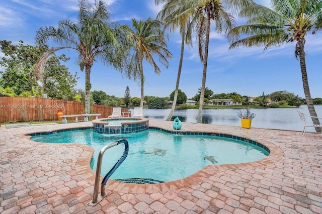 view of pool featuring a water view, a pool with connected hot tub, fence, and a patio area