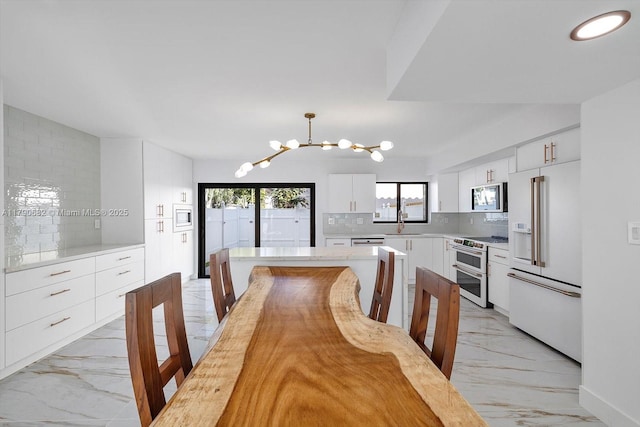 dining room featuring a chandelier and marble finish floor