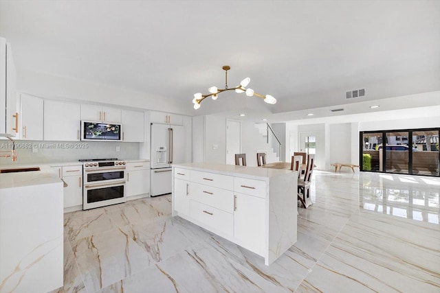 kitchen featuring an inviting chandelier, recessed lighting, a kitchen island, premium appliances, and visible vents