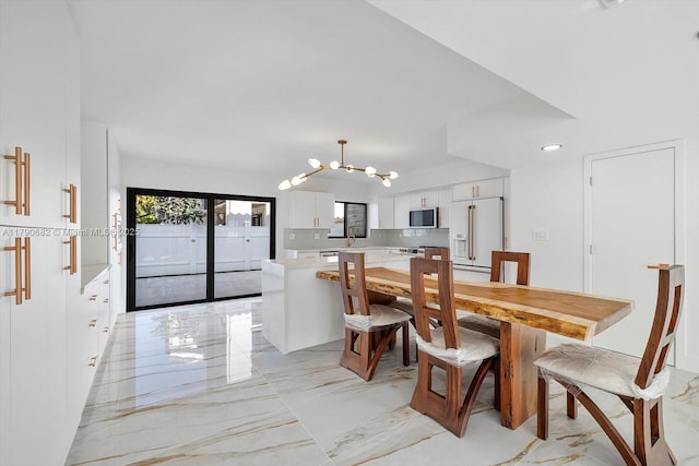 dining area featuring marble finish floor and a chandelier