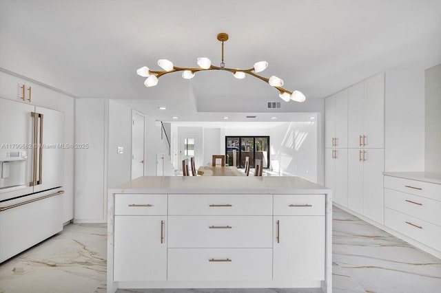 kitchen with high end white fridge, light countertops, a chandelier, marble finish floor, and visible vents