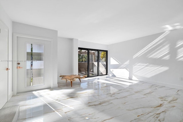 unfurnished room with baseboards and marble finish floor