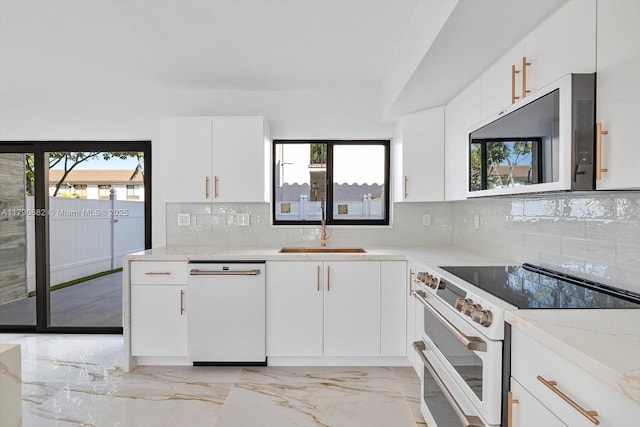 kitchen featuring white appliances, a wealth of natural light, a sink, and marble finish floor