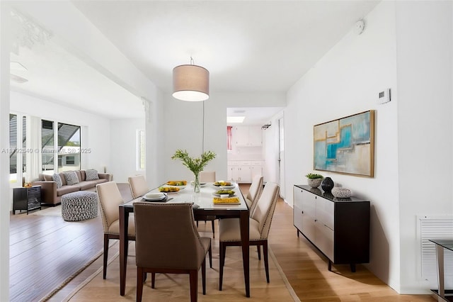 dining space featuring visible vents and light wood finished floors
