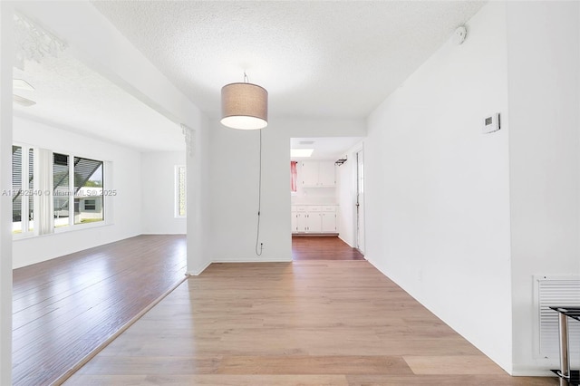 interior space featuring a textured ceiling and light wood-style flooring