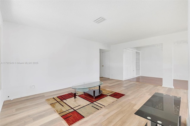 interior space featuring baseboards, visible vents, and wood finished floors