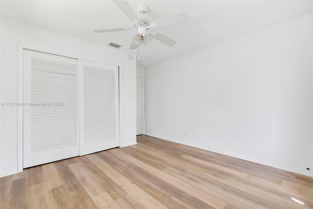unfurnished bedroom with visible vents, a ceiling fan, light wood finished floors, and a closet