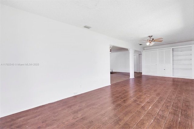 interior space featuring a ceiling fan, two closets, wood finished floors, and visible vents