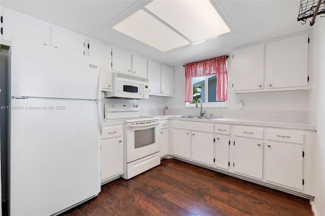 kitchen featuring white appliances, white cabinetry, a sink, and dark wood-style flooring