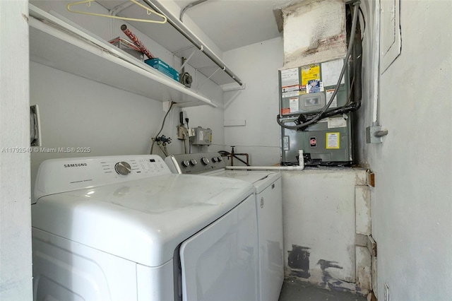 washroom with laundry area, heating unit, and separate washer and dryer