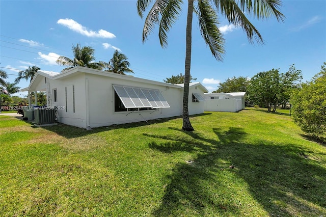 view of home's exterior featuring fence, central AC unit, and a yard