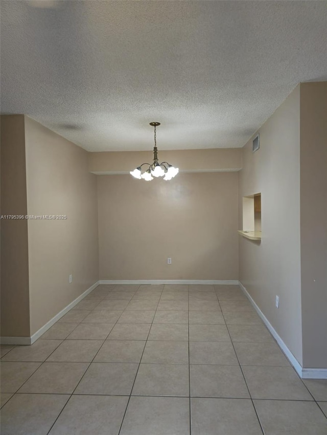 11750 SW 18th St Unit 403-1, Miami, FL 33175 - empty room featuring a textured ceiling, light tile patterned floors, a chandelier, and baseboards