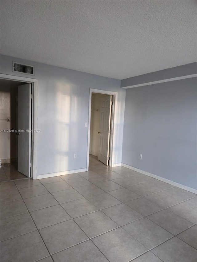 11750 SW 18th St Unit 403-1, Miami, FL 33175 - unfurnished bedroom with a textured ceiling, tile patterned floors, and baseboards