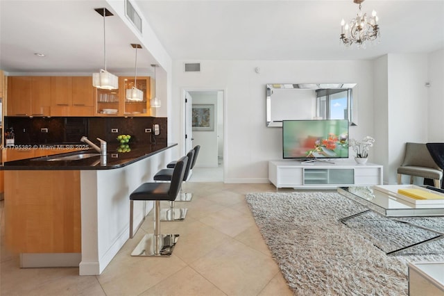 kitchen with backsplash, light tile patterned floors, visible vents, and a sink
