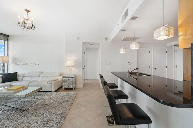living area featuring visible vents, baseboards, a chandelier, and light tile patterned flooring