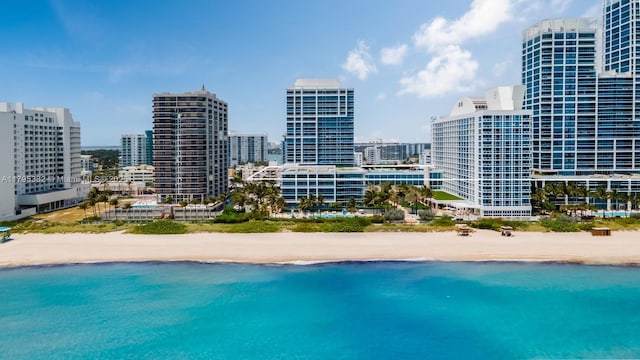 view of swimming pool featuring a view of city, a view of the beach, and a water view
