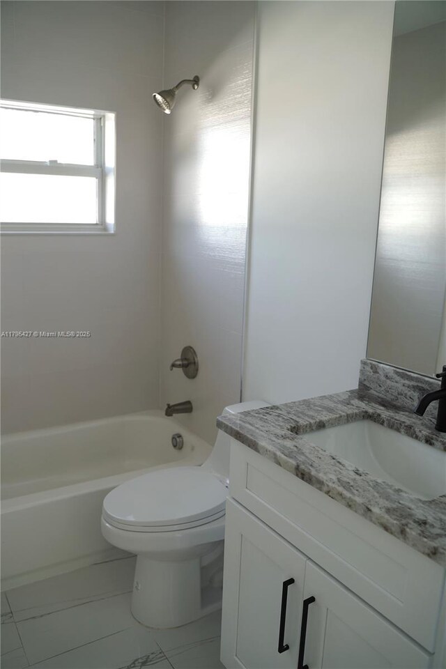bathroom with vanity, marble finish floor, tub / shower combination, and toilet