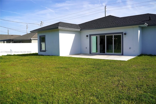 rear view of property featuring fence, stucco siding, a shingled roof, a patio area, and a yard