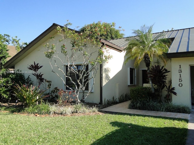 13150 SW 106th St, Miami, FL 33186 - view of home's exterior featuring a standing seam roof, stucco siding, a lawn, and metal roof