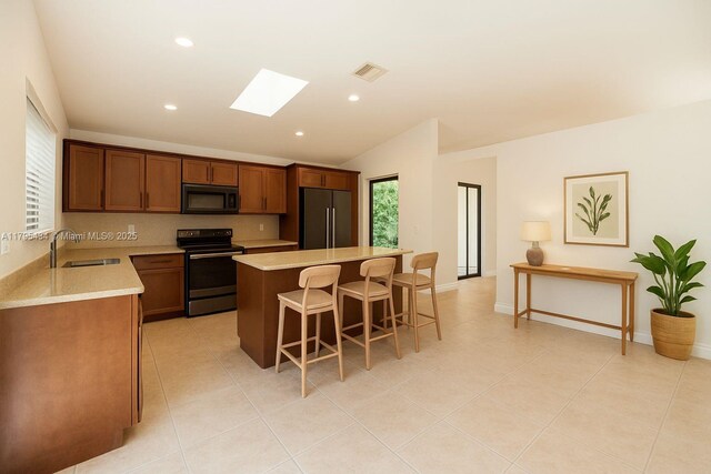 13150 SW 106th St, Miami, FL 33186 - kitchen with range with electric stovetop, visible vents, black microwave, refrigerator, and a sink