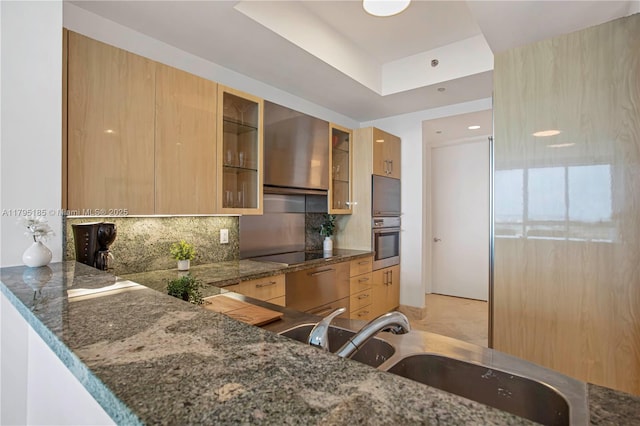 kitchen featuring glass insert cabinets, oven, modern cabinets, black electric cooktop, and tasteful backsplash