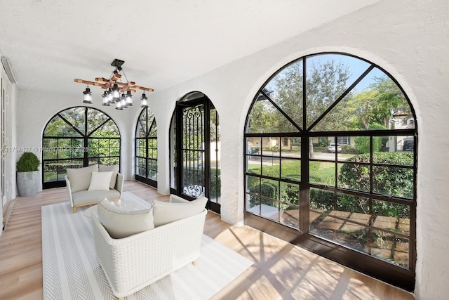 sunroom with an inviting chandelier and french doors