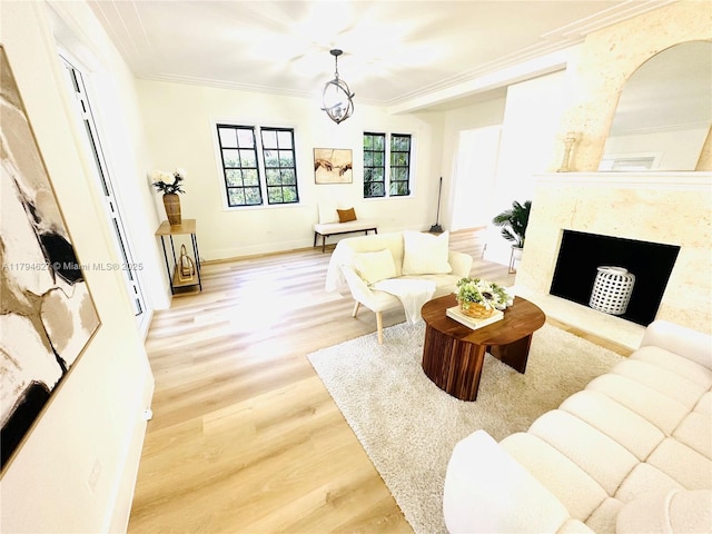 living area with baseboards, ornamental molding, wood finished floors, and a high end fireplace