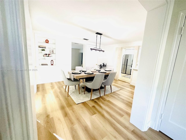 dining room with visible vents and light wood finished floors