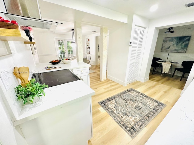 kitchen featuring light countertops, range with electric cooktop, range hood, light wood-type flooring, and visible vents