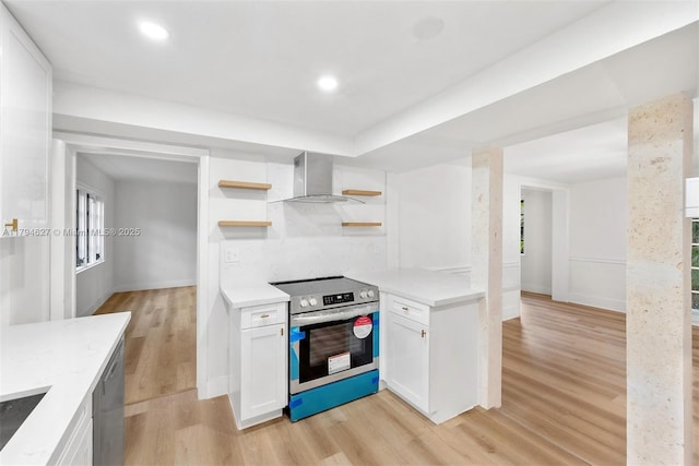 kitchen with wall chimney range hood, open shelves, appliances with stainless steel finishes, light wood finished floors, and white cabinetry