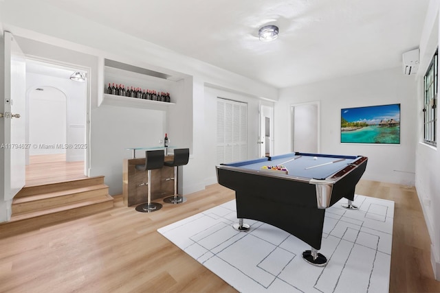 playroom featuring an AC wall unit, billiards, bar, and wood finished floors