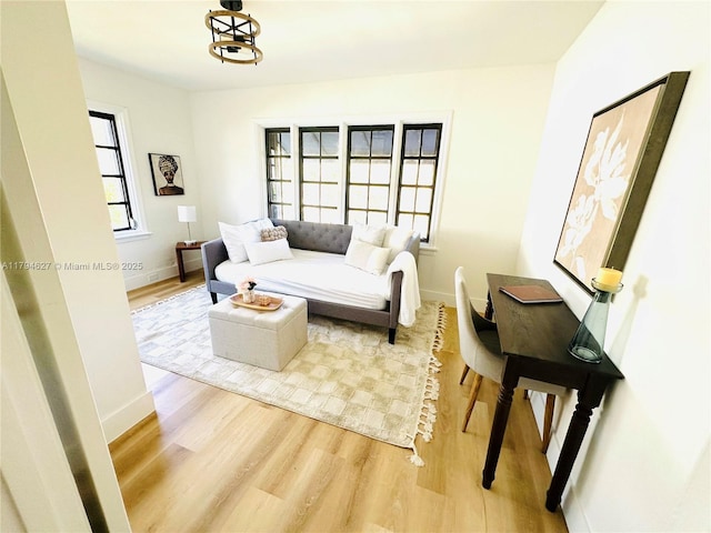 living area featuring baseboards and light wood finished floors