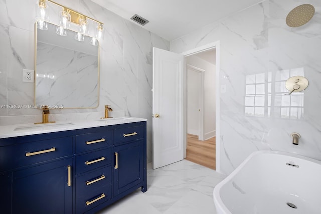 full bath with tile walls, visible vents, and a sink