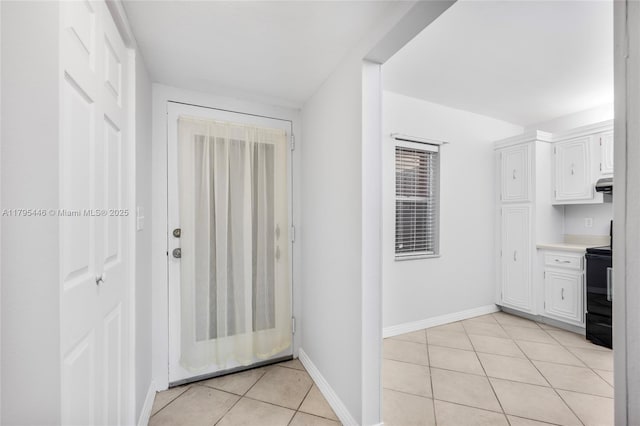 2861 Somerset Dr Unit 104, Lauderdale Lakes, FL 33311 - interior space featuring light countertops, stove, white cabinetry, baseboards, and light tile patterned floors