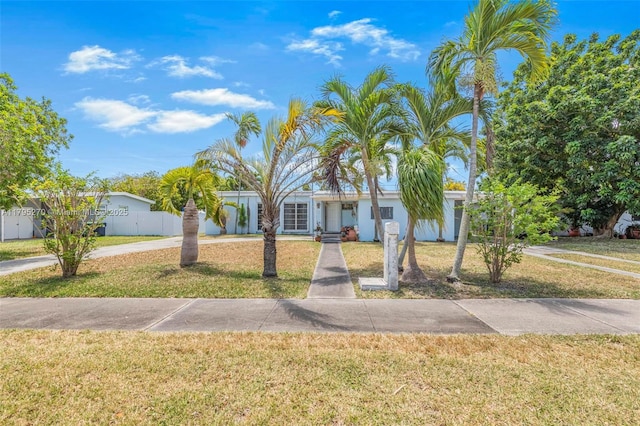 view of front facade featuring a front lawn and fence