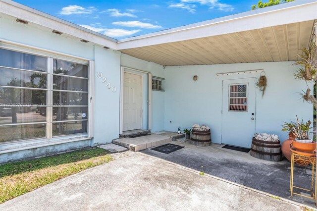 9240 Nautilus Dr, Cutler Bay, FL 33189 - view of exterior entry with a patio area and stucco siding