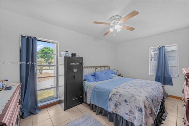 bedroom with a ceiling fan, a textured ceiling, and light tile patterned floors