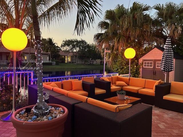 12307 NW 49th St, Coral Springs, FL 33076 - view of patio / terrace with an outdoor living space, a water view, and an outbuilding