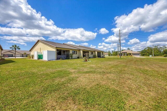 26136 Explorer St, Punta Gorda, FL 33983 - back of property with stucco siding and a yard