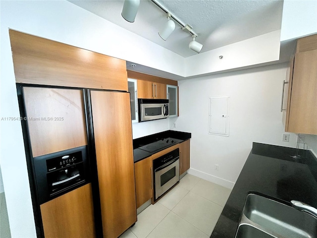 325 S Biscayne Blvd Unit 2917, Miami, FL 33131 - kitchen with appliances with stainless steel finishes, electric panel, rail lighting, light tile patterned floors, and brown cabinetry