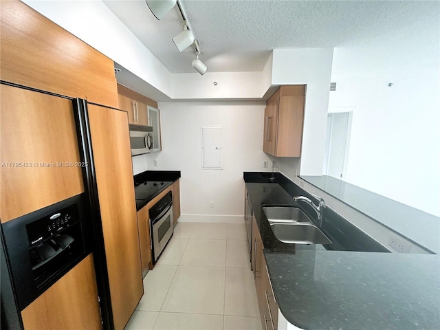 325 S Biscayne Blvd Unit 2917, Miami, FL 33131 - kitchen with appliances with stainless steel finishes, a sink, track lighting, brown cabinets, and light tile patterned flooring