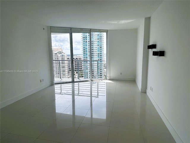 325 S Biscayne Blvd Unit 2917, Miami, FL 33131 - unfurnished room featuring floor to ceiling windows, baseboards, tile patterned flooring, and a city view