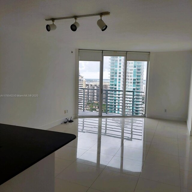325 S Biscayne Blvd Unit 2917, Miami, FL 33131 - spare room with a wall of windows, light tile patterned flooring, and baseboards