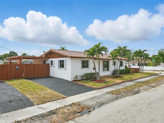 6800 Hope St, Hollywood, FL 33024 - view of front facade featuring a tiled roof, fence, and stucco siding