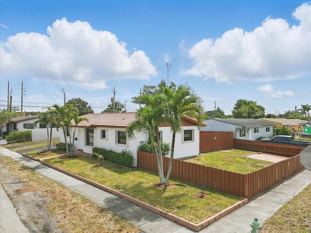 6800 Hope St, Hollywood, FL 33024 - view of front of home featuring stucco siding, fence private yard, and a front yard