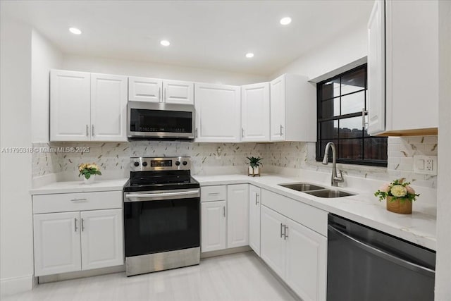6800 Hope St, Hollywood, FL 33024 - kitchen featuring backsplash, appliances with stainless steel finishes, a sink, light countertops, and white cabinets
