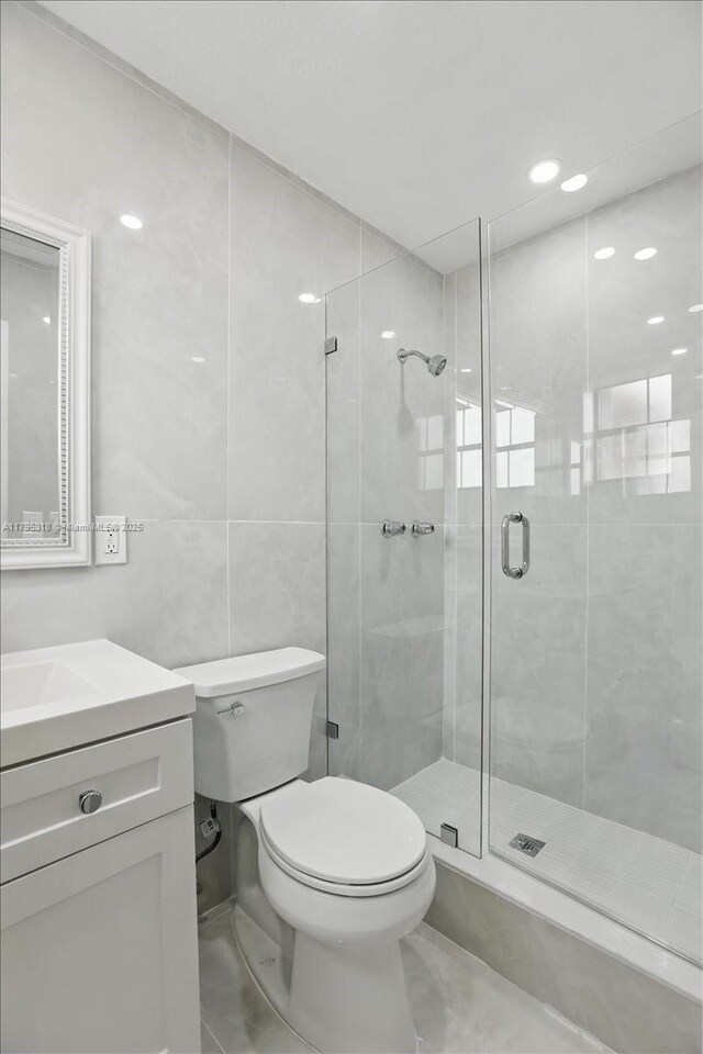 6800 Hope St, Hollywood, FL 33024 - full bathroom with vanity, tile walls, a stall shower, and toilet