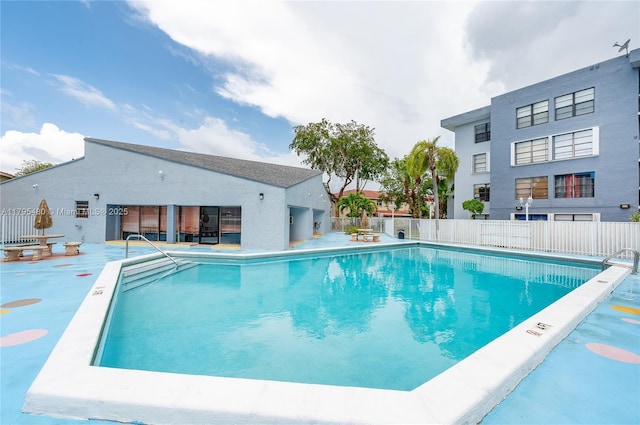 pool with a patio and fence