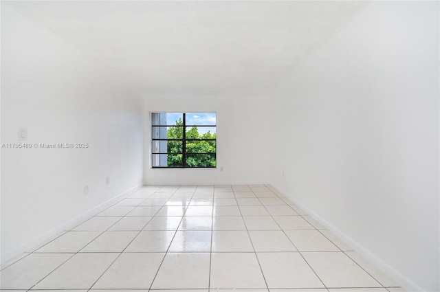 spare room featuring baseboards and light tile patterned floors