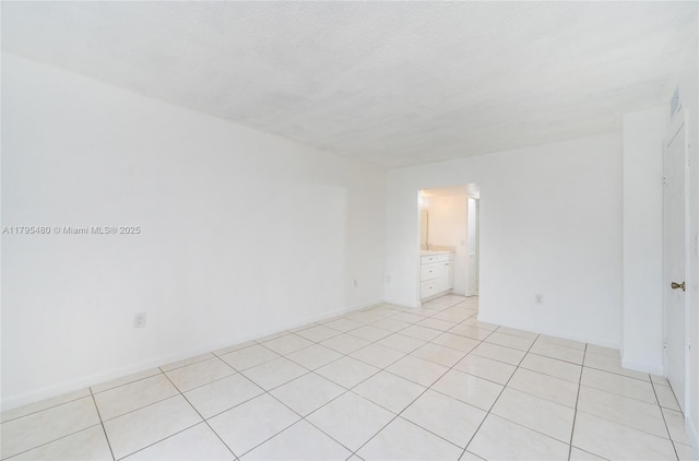 unfurnished room with light tile patterned floors and visible vents